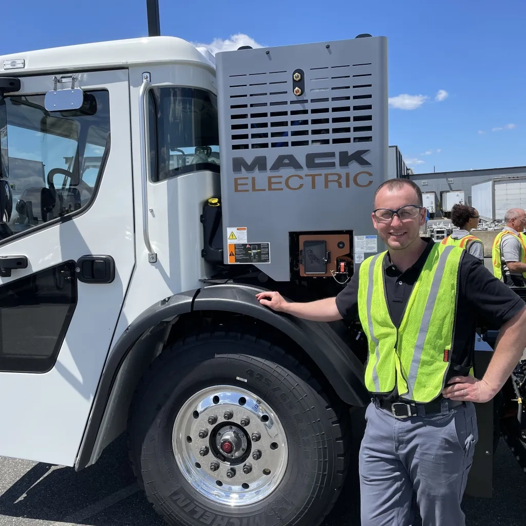 Dan Robb next to an electric mack truck. 